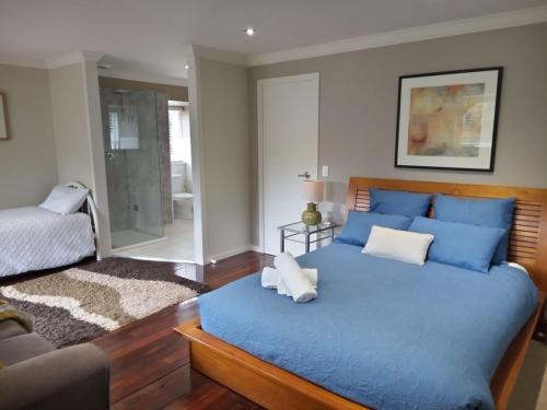 a large blue bed in a room with a couch at Beautiful Dutch Barn style country house in Merrijig (base of Mt Buller). in Merrijig