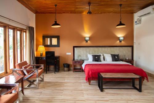 una camera da letto con un grande letto con una coperta rossa di ili-ah ki a Dimāpur
