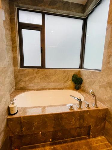 a bathroom with a bath tub with a window at R&F PRINCESS COVE at ANJU in Johor Bahru