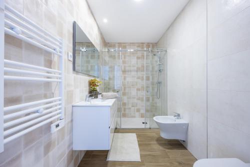 La salle de bains est pourvue d'un lavabo, de toilettes et d'un miroir. dans l'établissement Filha do Pisco, à Burgau