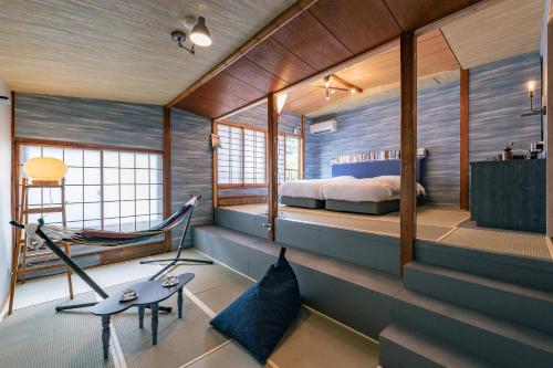 um quarto com uma cama e uma rede de descanso em 湯河原温泉 夢十夜 em Yugawara