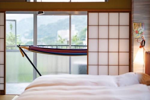 a bedroom with a bed and a large window at 湯河原温泉 夢十夜 in Yugawara