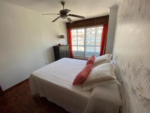 um quarto com uma cama com uma almofada vermelha em Gamboa em Vigo