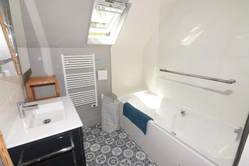 bagno con vasca bianca e lavandino di Les Pins Maison Vue sur Mer a Hautot-sur-Mer