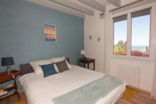 una camera con un grande letto e due finestre di Les Pins Maison Vue sur Mer a Hautot-sur-Mer