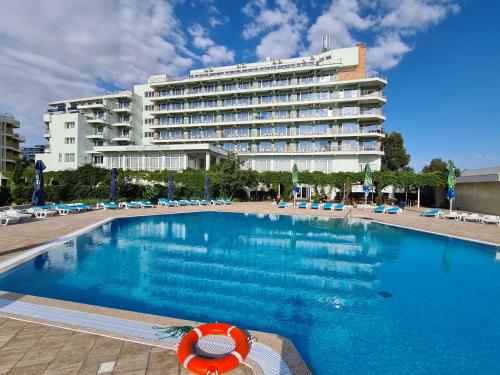 a large swimming pool in front of a hotel at Hotel Comandor in Mamaia