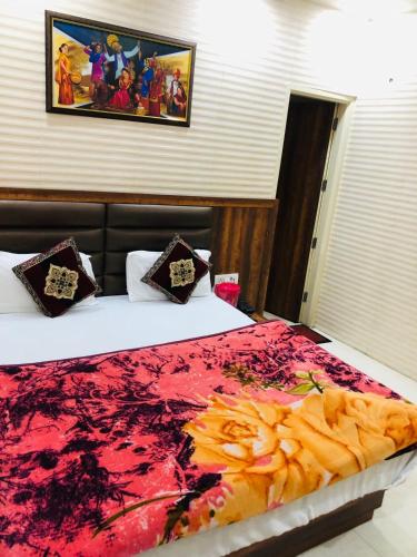 a bedroom with two beds with a red blanket at Jasneet Homestay in Amritsar