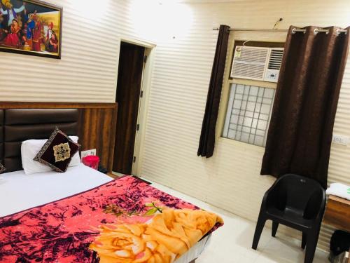 a bedroom with a bed and a chair and a window at Jasneet Homestay in Amritsar