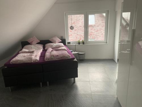 a bedroom with a bed with purple blankets and pillows at Apartment in ruhiger Lage am Rande des Ruhrgebietes in Bottrop