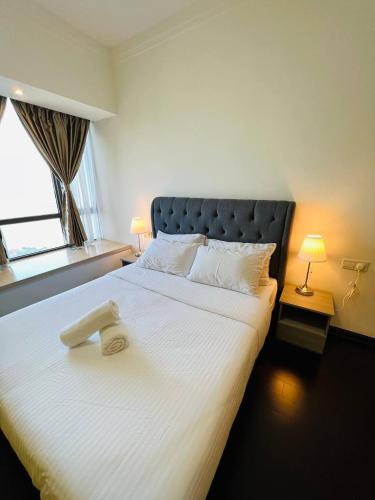 a bedroom with a large white bed with a window at R&F PRINCESS COVE at ANJU in Johor Bahru