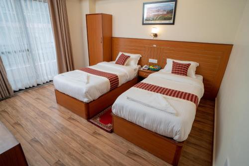 a room with two beds in a hotel room at Madhuban Hotel in Kathmandu