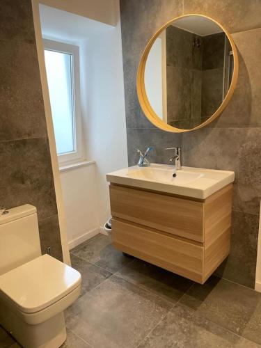 a bathroom with a sink and a toilet and a mirror at Casa de la plaza in Foz