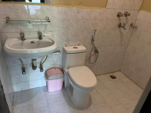 a bathroom with a toilet and a sink at Nepali Cottage Guest House in Pokhara