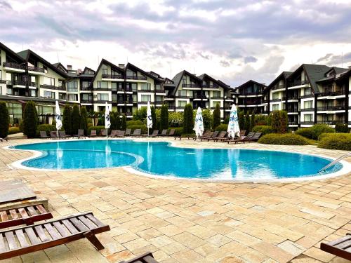 a swimming pool in front of some apartment buildings at Pirin Dream View Apartments in Razlog