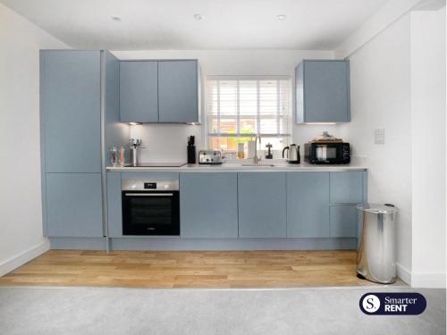 a kitchen with blue cabinets and a stove top oven at Eton, Windsor - 1 Bedroom Ground Floor Apartment - With Parking in Eton