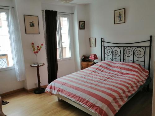 sypialnia z łóżkiem z czerwonym i białym kocem w obiekcie B1 Appartement en centre ville de Courtenay w mieście Courtenay