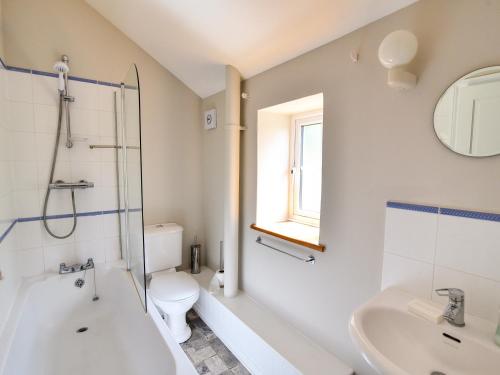 a bathroom with a shower toilet and a sink at Damson Tree Cottage in Bridport