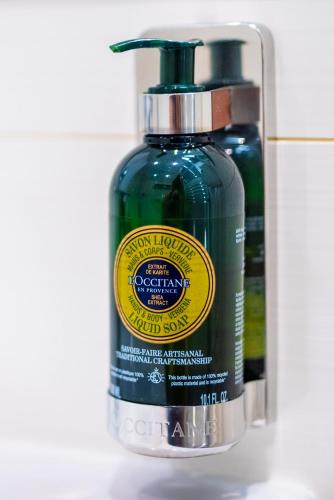 a bottle of green liquid next to a container of soap at Hotel Větruše in Ústí nad Labem