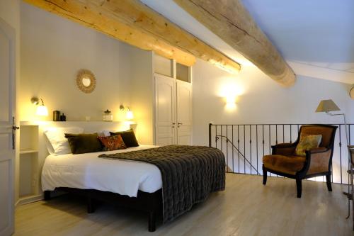 シャントメルル・レ・グリニャンにあるドメーヌ ル ボワ デ ダムのベッドルーム(大型ベッド1台、椅子付)
