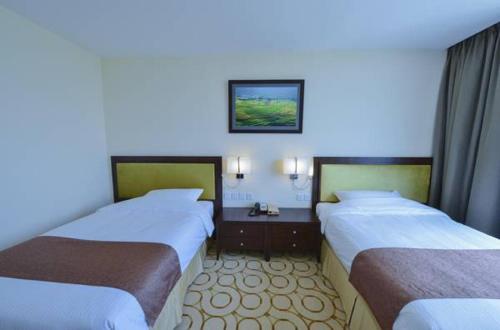 Ένα ή περισσότερα κρεβάτια σε δωμάτιο στο Aristo International Hotel