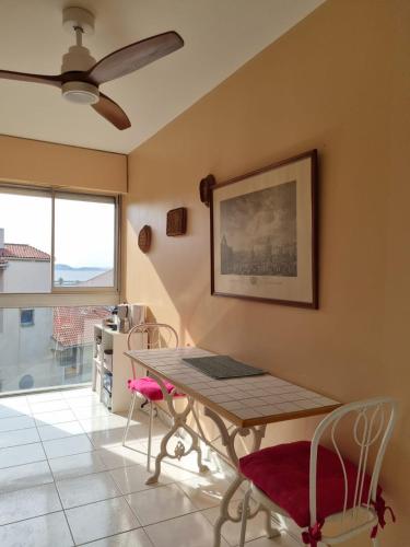 une salle à manger avec une table et des chaises et un ventilateur de plafond dans l'établissement Spacieux appartement vue mer panoramique & parking, à Marseille