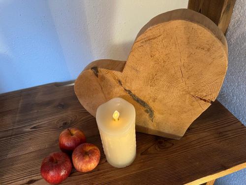 a candle and some apples on a wooden table at Berghof am Schwand in Hinterhornbach