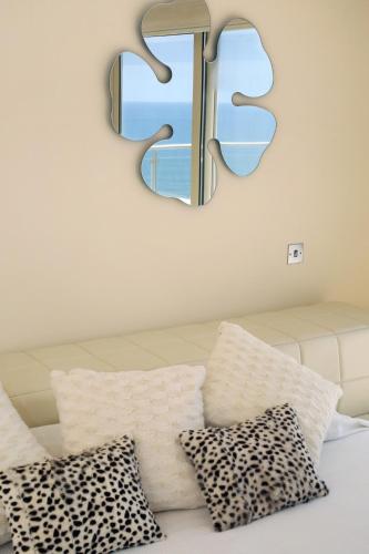 a mirror on a wall above a bed with pillows at Seafront 5 Bedroom Villa Paradise in Sea Caves in Peyia