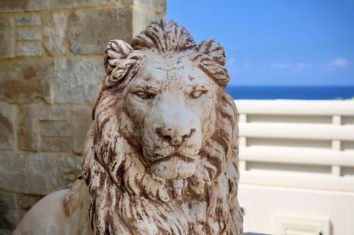 a statue of a lion in front of a building at Seafront 5 Bedroom Villa Paradise in Sea Caves in Peyia