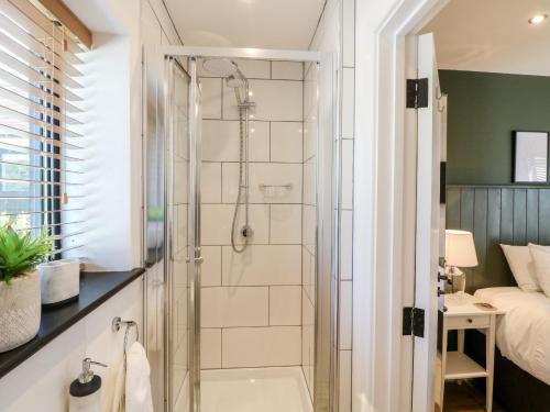 a bathroom with a shower and a bath tub at The Wood Shed, Bank Top Farm in Ashbourne