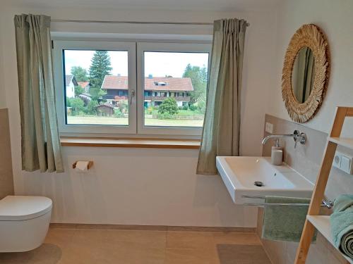 ein Bad mit einem WC, einem Waschbecken und einem Fenster in der Unterkunft Ferienwohnung Bergblick Loft in Aschau im Chiemgau