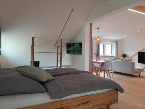 a bedroom with a large bed and a living room at Ferienwohnung Bergblick Loft in Aschau im Chiemgau