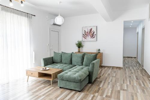 sala de estar con sofá verde y mesa en Myrte's View, en Asómatoi