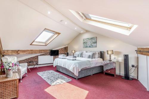 a attic bedroom with a bed and a tv at Dragon Loft Apartment in Harrogate