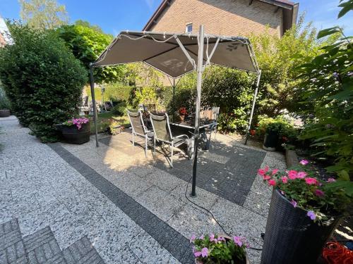 a table and chairs under an umbrella on a patio at Pension Auberge de Dael in Valkenburg