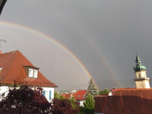 un arco iris sobre una ciudad con un faro en el fondo en Aalens schönste Aussicht, en Aalen