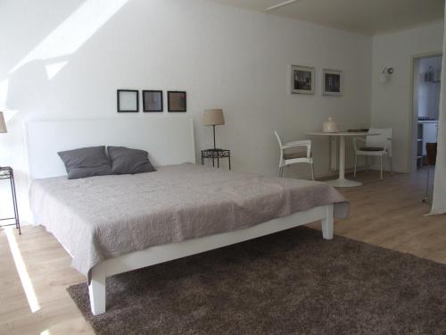 een slaapkamer met een bed en een tafel en stoelen bij Das Stadthaus in Bad Salzuflen