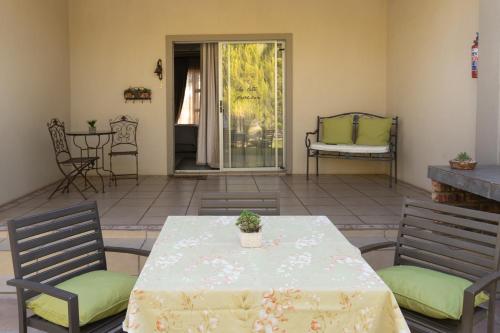 eine Terrasse mit einem Tisch und 2 Stühlen sowie einem Tisch und Stühlen in der Unterkunft The Falls Guest House in Augrabies