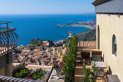 a balcony with a view of a city and the ocean at Hotel Villa Ducale in Taormina