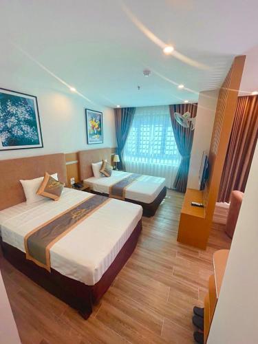 pokój hotelowy z 2 łóżkami i telewizorem w obiekcie Khách sạn Thiên Đường - Paradise Hotel w mieście Yên Lô