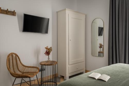 a bedroom with a bed and a chair and a mirror at BYPILLOW La Sal in Cádiz