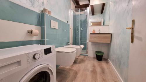 a bathroom with a washing machine and a toilet at Casa Vald in Trieste