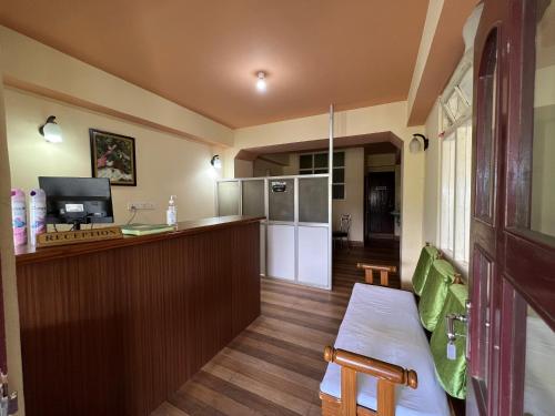a kitchen with a bar and a counter with a refrigerator at Khandroling Hotel in Gangtok