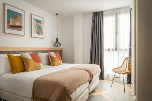 Habitación de hotel con 2 camas y ventana en BYPILLOW La Sal en Cádiz