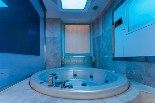 a blue bathroom with a large tub in a room at Hotel Trecento in Rome