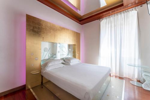 a bedroom with a white bed and a window at Hotel Trecento in Rome