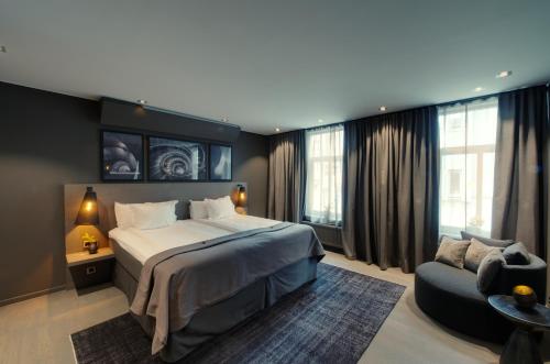 a bedroom with a large bed and a couch at The Lamp Hotel & Spa in Norrköping