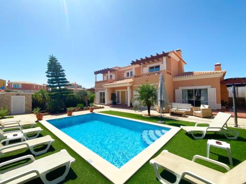 a villa with a swimming pool in front of a house at Casa Moreira in Lagos