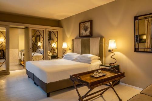 a bedroom with a large bed and a table at Hotel Villa Ducale in Taormina