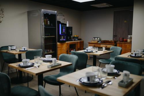 ein Restaurant mit Tischen und Stühlen mit Tassen darauf in der Unterkunft Keystone Boutique Hôtel in Lyon