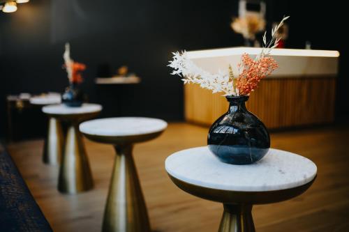 two stools with a vase with flowers on them at Keystone Hôtel & Spa in Lyon